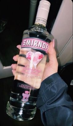 a person holding a bottle of vodka with the label gnarnof on it