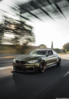 a car driving down the road with blurry trees in the background