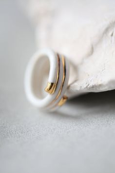 two gold and white rings sitting on top of a rock