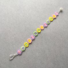 a beaded bracelet with multicolored beads and silver clasp on a gray surface