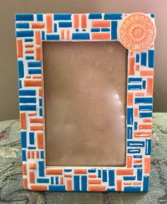 an orange, blue and white frame sitting on top of a bed