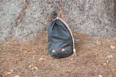 a black bag sitting on the ground next to a tree