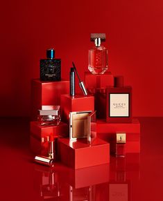 a red table topped with different types of perfumes