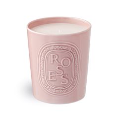 a pink candle with the words roses on it in front of a white background,