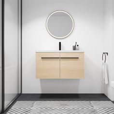 a white bathroom with a round mirror above the sink and wooden cabinet on the wall