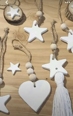 white wooden ornaments with tassels and string on wood table top, including star ornament