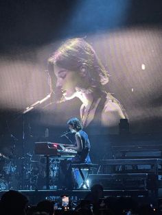 a woman standing on top of a keyboard in front of a crowd