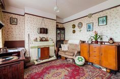 an old fashioned living room with floral wallpaper