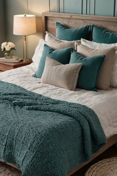 a bed with blue and white comforters in a bedroom next to a lamp on a table