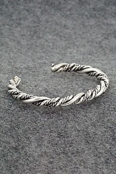 This "braided" sterling silver bracelet was made by Navajo silversmith Elaine Tahe.Size: 5" (will fit up to a 6 1/4" wrist)Gap: 1 1/4"Width: 1/4"Free shipping on all orders! We ship with USPS and always include tracking. All orders ship within a day of payment.Returns are accepted up to 30 days after you receive your order. Just send us a message. Our shop offers cash back or store credit. The item must be returned in new condition. Braided Sterling Silver Bracelet, Silver Sterling Braided Bracelets, Silver Adjustable Twisted Bracelets, Adjustable Twisted Silver Bracelets, Silver Braided Bohemian Bracelets, Bohemian Silver Braided Bracelet, Silver Hand-wrapped Braided Bangle Bracelet, Hand-wrapped Silver Braided Bangle Bracelet, Silver Hand Wrapped Braided Bangle Bracelet