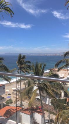 a balcony with palm trees and the ocean in the background