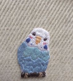 a small blue and white bird sitting on top of a beige cloth covered tablecloth