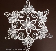 a white snowflake on a black background with the words menka's rangoli written in it