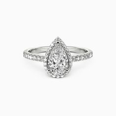 a pear shaped diamond engagement ring on a white background