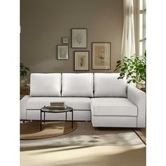 a living room with a white sectional couch and coffee table in front of a window