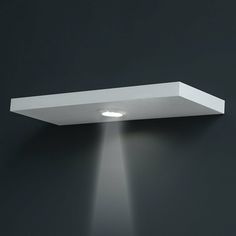 a wall light that is on the side of a wall with a spotlight coming from it