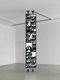 a tall black and white sculpture in an empty room