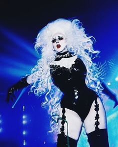 a woman with white hair and makeup on stage