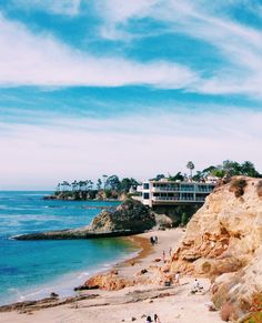 people are walking on the beach by the water