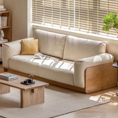 a living room with a couch, coffee table and bookshelf in the corner