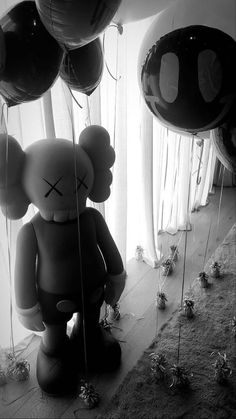 an inflatable teddy bear is surrounded by balloons