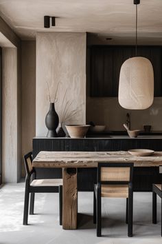 a wooden table sitting in the middle of a living room next to a vase and lamp