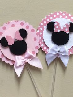 two minnie mouse cupcake toppers with pink and white polka dot paper on them