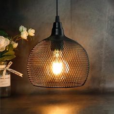 a light that is on top of a table next to some flowers and a jar