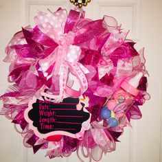 a pink wreath with a blackboard saying love you more than time on the front door