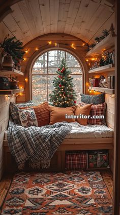 a christmas tree is in the corner of a window sill with pillows and blankets on it