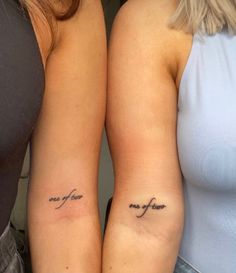 two women with matching tattoos on their arms, one has the word love and the other is