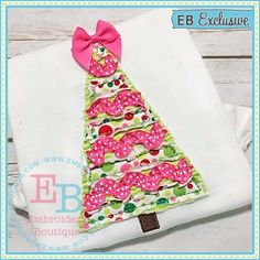 a christmas tree appliqued on top of a white shirt with pink bow