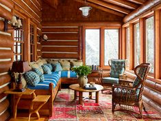 a living room filled with lots of furniture next to wooden walls and flooring covered in wood