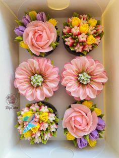 cupcakes decorated with flowers in a box