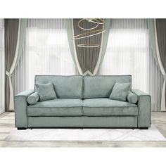 a living room scene with focus on the couch and curtained window behind it's drapes