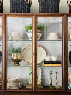 a china cabinet filled with plates and vases