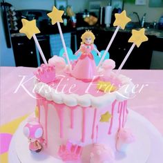 there is a pink cake with stars on it and a princess figurine in the middle