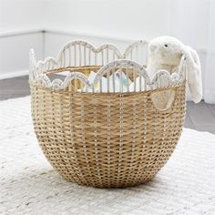 a wicker basket with a stuffed animal in it on a white rug next to a window