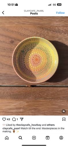 a yellow bowl sitting on top of a wooden table