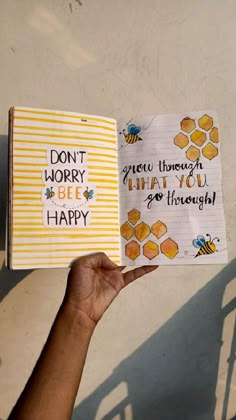 a person holding up a book with writing on it that says don't worry, grow through what you do through happy