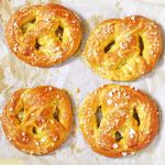 four pastries sitting on top of a piece of wax paper next to each other