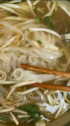 the soup is prepared and ready to be eaten with two wooden spoons in it