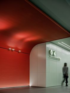 a person walking in front of a red and white wall with the number 37 on it