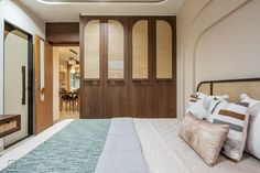 a large bed sitting in a bedroom next to a wooden door with glass panels on it