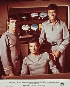 three men in star trek uniforms standing next to each other