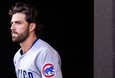 a man with a beard wearing a chicago cubs baseball jersey and looking off to the side