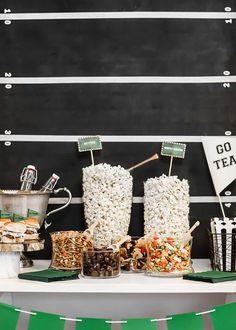 an image of popcorn bar set up with snacks and treats on the table for guests to eat