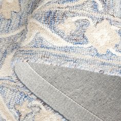 the corner of a blue and white rug with an area rug on top of it