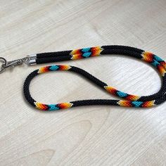 a multicolored dog leash on a wooden table