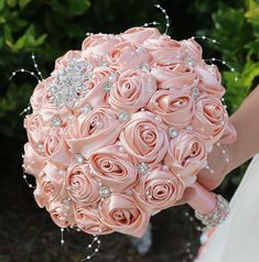 the bride's bouquet is made up of pink roses and swaroed jewels